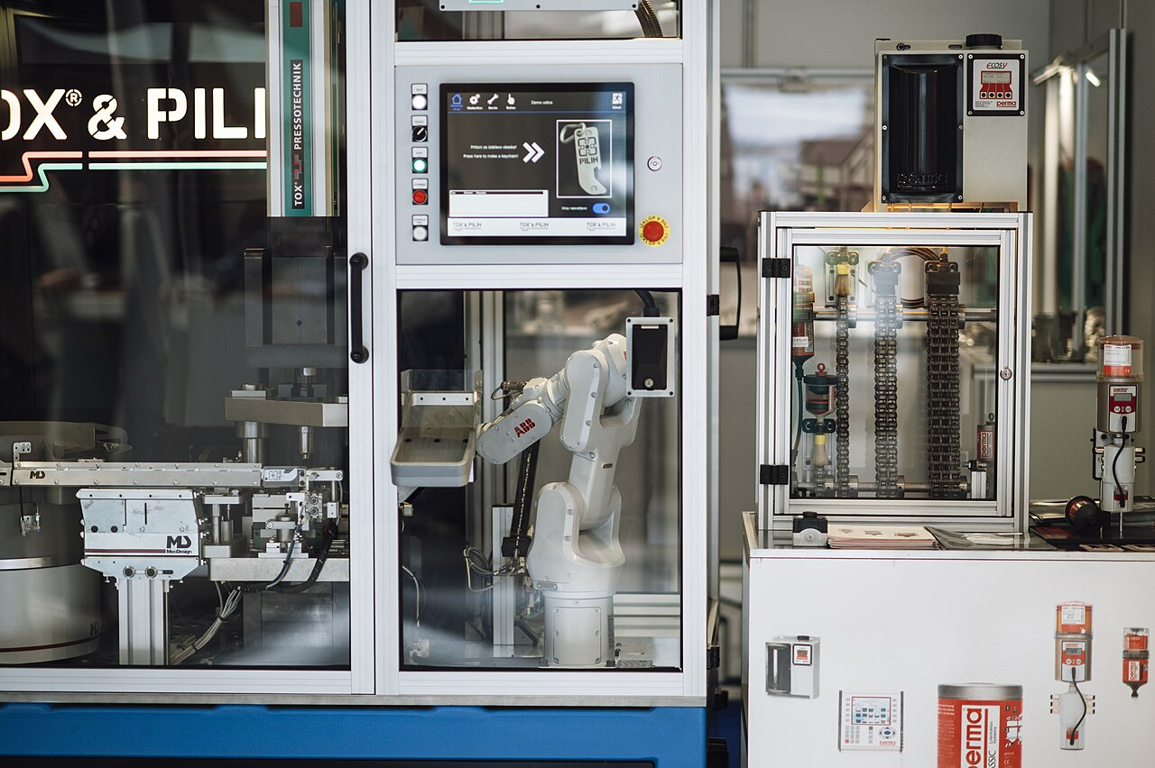 Industrial robotic arm beside manufacturing machinery