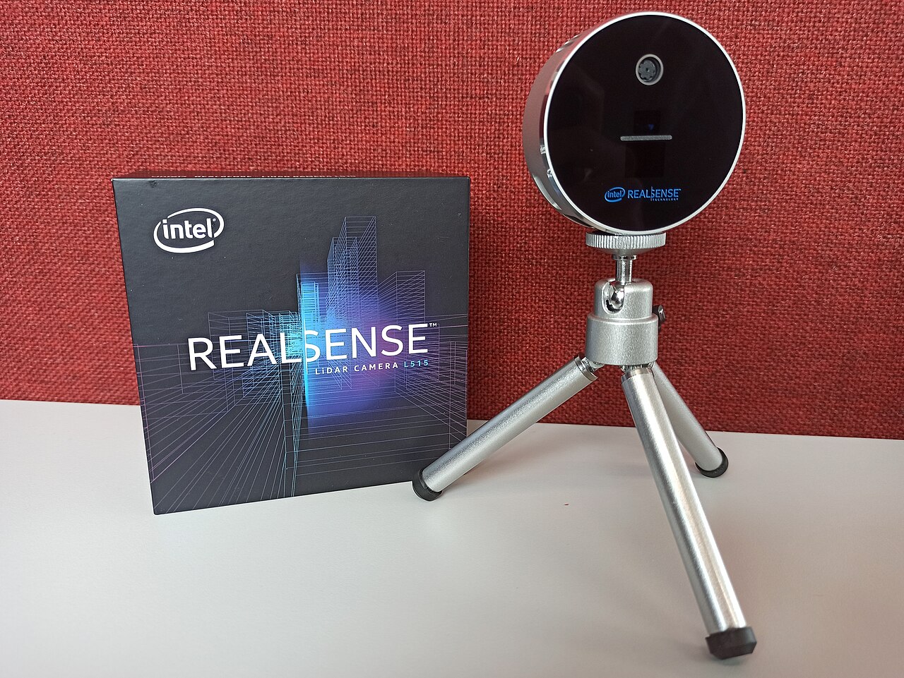 Intel RealSense L515 lidar camera on a small tripod beside its box